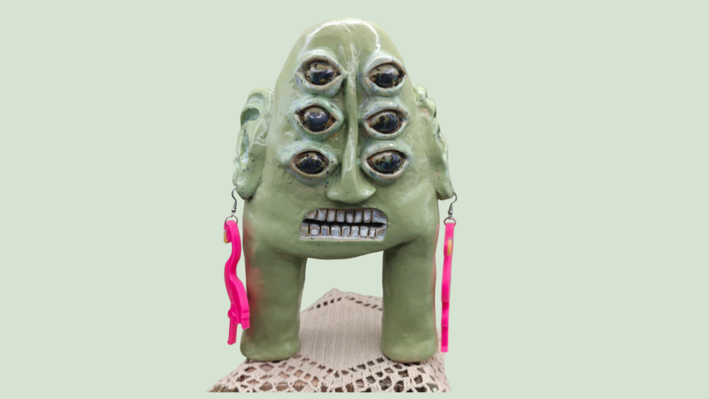 Abstract groen monster van 3D met zes ogen en roze flamingo oorbellen
